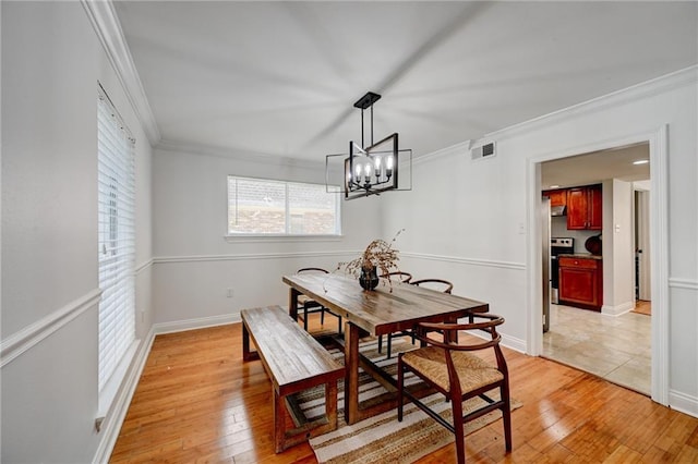 4043 S Inwood Ave, New Orleans, LA 70131 - dining room featuring crown molding, light wood finished floors, and a chandelier