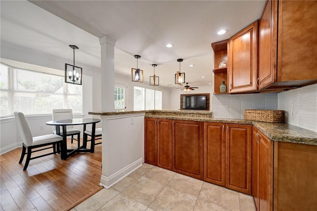 4043 S Inwood Ave, New Orleans, LA 70131 - kitchen with brown cabinetry, dark stone countertops, a peninsula, decorative backsplash, and recessed lighting