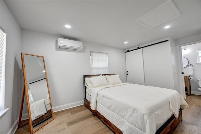 4043 S Inwood Ave, New Orleans, LA 70131 - bedroom with a wall mounted AC, recessed lighting, light wood-style flooring, and a barn door