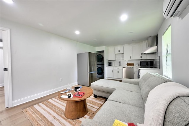 4043 S Inwood Ave, New Orleans, LA 70131 - living area with an AC wall unit, stacked washer / drying machine, light wood-style flooring, and recessed lighting