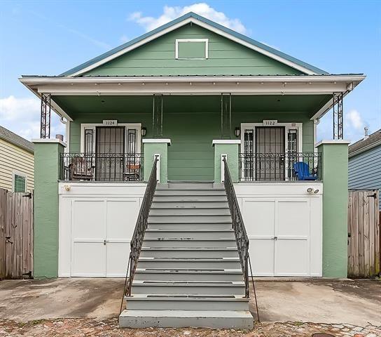 112224 N Johnson St, New Orleans, LA 70116 - shotgun-style home featuring covered porch, stairway, a garage, and a metal roof
