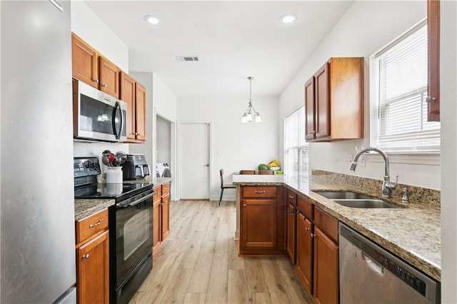 5233 Savannah Ln, Marrero, LA 70072 - kitchen with stainless steel appliances, light wood finished floors, a peninsula, a chandelier, and decorative light fixtures