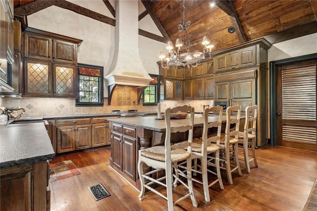 266 Wpa Rd, Ms, MS 39459 - kitchen featuring dark wood-type flooring, a wood ceiling with exposed beams, a center island, a kitchen bar, and tasteful backsplash