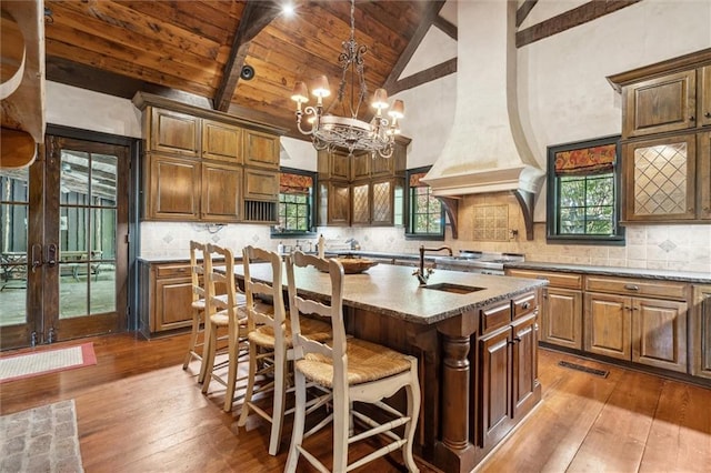 266 Wpa Rd, Ms, MS 39459 - kitchen with dark wood finished floors, a wooden ceiling with exposed beams, a chandelier, a center island with sink, and light stone countertops