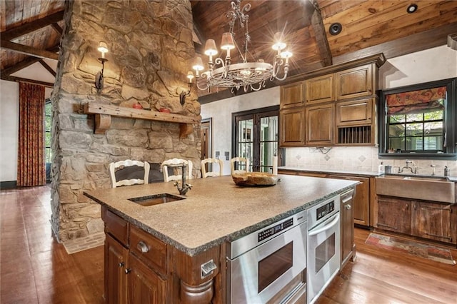 266 Wpa Rd, Ms, MS 39459 - kitchen with oven, hardwood / wood-style floors, a chandelier, a center island with sink, and decorative backsplash