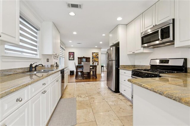 1213 Haring Rd, Metairie, LA 70001 - kitchen with stainless steel appliances, white cabinetry, recessed lighting, and light stone countertops