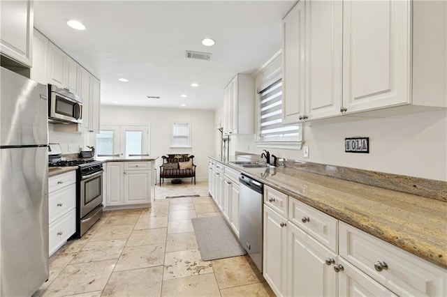 1213 Haring Rd, Metairie, LA 70001 - kitchen with stainless steel appliances, white cabinetry, and recessed lighting
