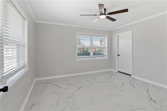 1139 Nursery Ave, Metairie, LA 70005 - spare room with light marble finish flooring, a ceiling fan, and ornamental molding