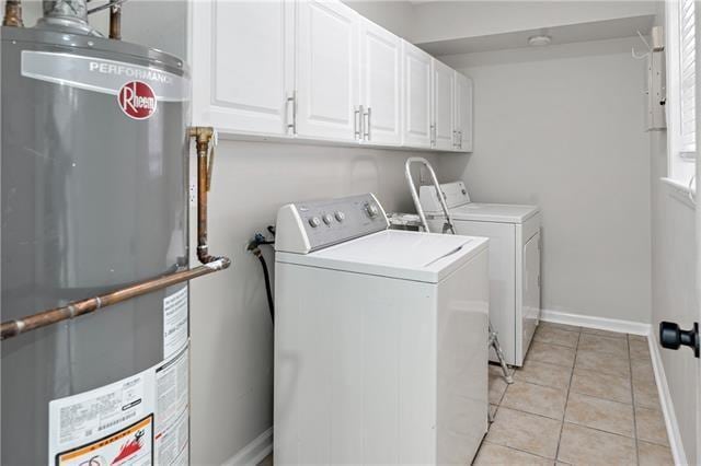1139 Nursery Ave, Metairie, LA 70005 - laundry room with water heater, washing machine and clothes dryer, light tile patterned flooring, and cabinet space