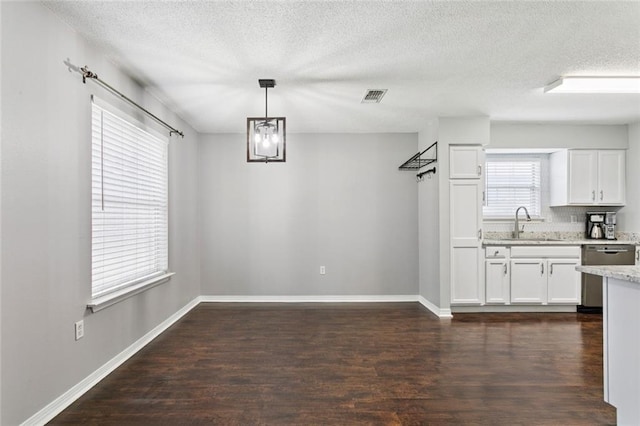 834 Mongrue St, Luling, LA 70070 - unfurnished dining area featuring a textured ceiling, dark wood-type flooring, and a chandelier