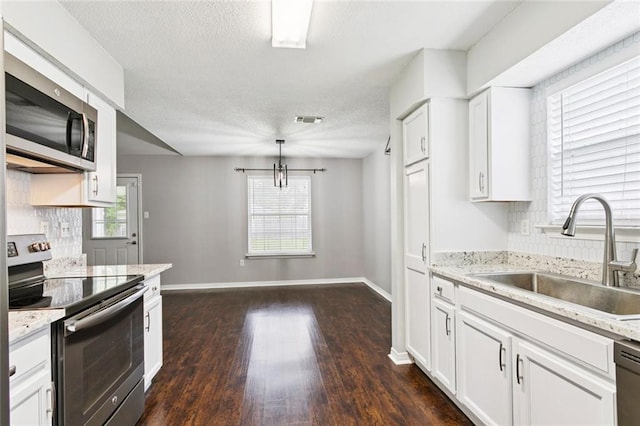 834 Mongrue St, Luling, LA 70070 - kitchen with appliances with stainless steel finishes, white cabinets, dark wood-type flooring, a textured ceiling, and a chandelier