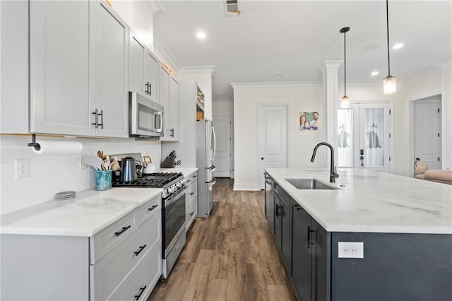 218 Belle Ormond Cir, Destrehan, LA 70047 - kitchen featuring stainless steel appliances, ornamental molding, dark wood finished floors, an island with sink, and decorative light fixtures