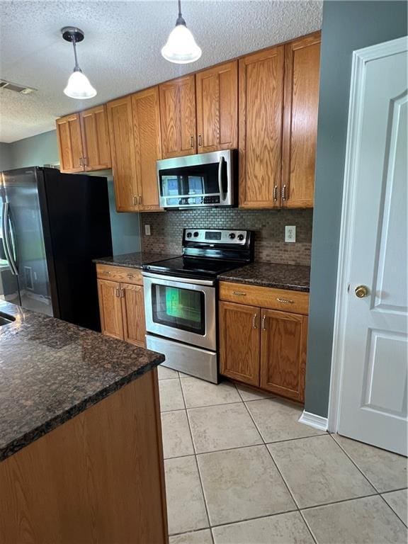 2712 Bayou Bleu Dr, Marrero, LA 70072 - kitchen with appliances with stainless steel finishes, brown cabinets, a textured ceiling, light tile patterned floors, and hanging light fixtures