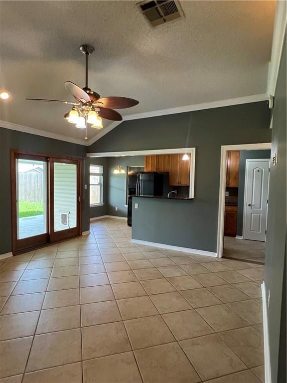 2712 Bayou Bleu Dr, Marrero, LA 70072 - kitchen featuring ornamental molding, dark countertops, lofted ceiling, light tile patterned flooring, and black fridge with ice dispenser