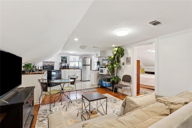 1801 Adams St, New Orleans, LA 70118 - living room with light wood finished floors, vaulted ceiling, and recessed lighting