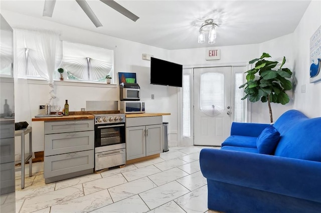 1801 Adams St, New Orleans, LA 70118 - kitchen with gray cabinets, stainless steel appliances, light marble finish floors, wooden counters, and ceiling fan