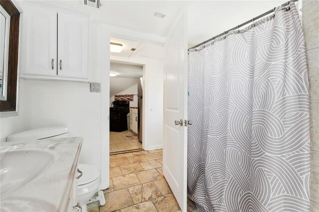 1801 Adams St, New Orleans, LA 70118 - bathroom with stone tile floors and vanity