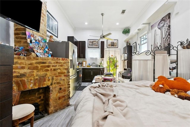 1801 Adams St, New Orleans, LA 70118 - bedroom with ornamental molding, recessed lighting, wood finished floors, a brick fireplace, and stainless steel fridge