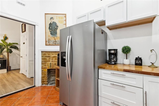 1801 Adams St, New Orleans, LA 70118 - kitchen featuring stainless steel refrigerator with ice dispenser, wood counters, white cabinetry, and light tile patterned floors