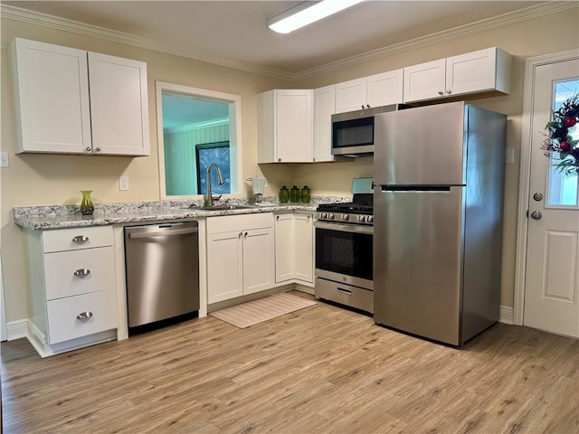 137 Diane Ave, River Ridge, LA 70123 - kitchen featuring appliances with stainless steel finishes, white cabinetry, ornamental molding, light wood-style flooring, and light stone counters