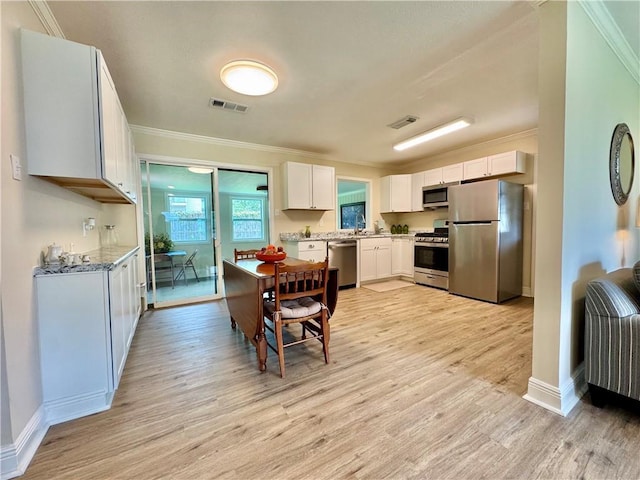137 Diane Ave, River Ridge, LA 70123 - kitchen featuring stainless steel appliances, crown molding, light wood finished floors, and white cabinets