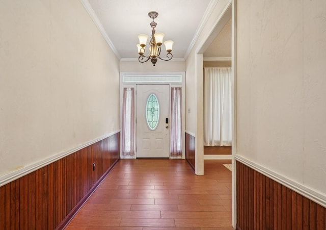 16233 Cody Ln, Covington, LA 70435 - foyer with a chandelier, a wainscoted wall, ornamental molding, wood-type flooring, and wood walls