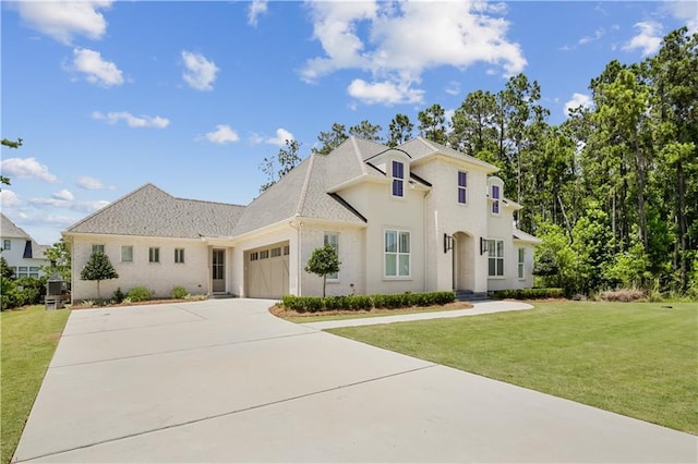 128 Juniper Ct, Mandeville, LA 70471 - french country style house featuring an attached garage, concrete driveway, a front yard, and stucco siding
