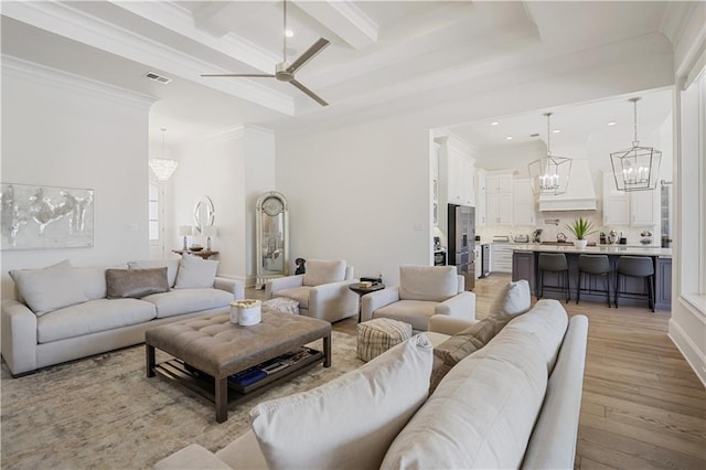 128 Juniper Ct, Mandeville, LA 70471 - living area with a chandelier, light wood-type flooring, ceiling fan, ornamental molding, and beam ceiling