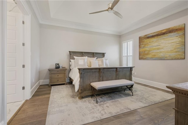 128 Juniper Ct, Mandeville, LA 70471 - bedroom featuring ornamental molding, wood finished floors, a tray ceiling, and ceiling fan
