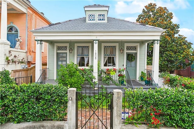 1808 N Rampart St, New Orleans, LA 70116 - view of front of home with a porch, a shingled roof, and a fenced front yard