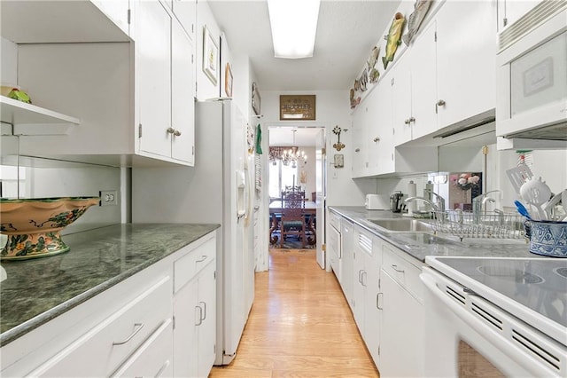 1550 2nd St Unit 4A, New Orleans, LA 70130 - kitchen featuring white appliances, white cabinetry, light wood-style floors, and a chandelier