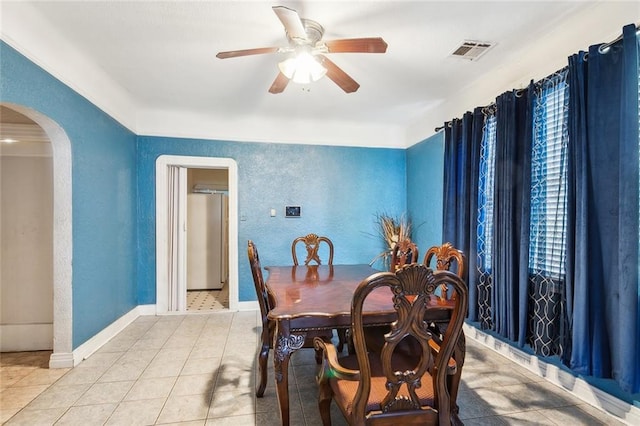 1018 Reynes Dr, New Orleans, LA 70117 - dining room with arched walkways, a ceiling fan, light tile patterned floors, and a textured wall