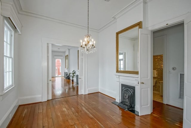 3713 Carondelet St, New Orleans, LA 70115 - unfurnished living room featuring wood-type flooring, a chandelier, ornamental molding, and a fireplace