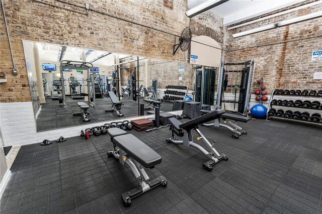 920 Poeyfarre St Unit 161, New Orleans, LA 70131 - gym with a towering ceiling and brick wall