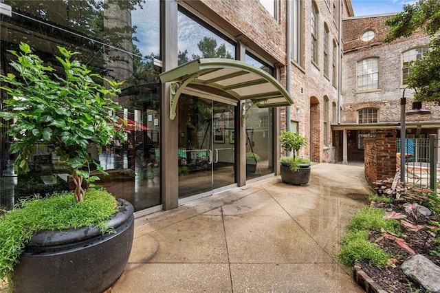 920 Poeyfarre St Unit 161, New Orleans, LA 70131 - view of exterior entry featuring brick siding and a patio