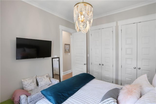 1537 Darlington St, Covington, LA 70433 - bedroom with two closets, a chandelier, and ornamental molding