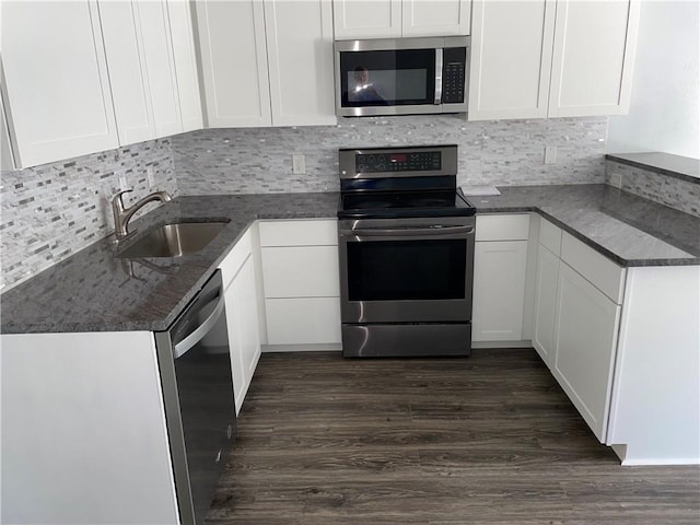 176 Meadowmoss Dr, Slidell, LA 70458 - kitchen featuring appliances with stainless steel finishes, dark wood-type flooring, white cabinets, and decorative backsplash