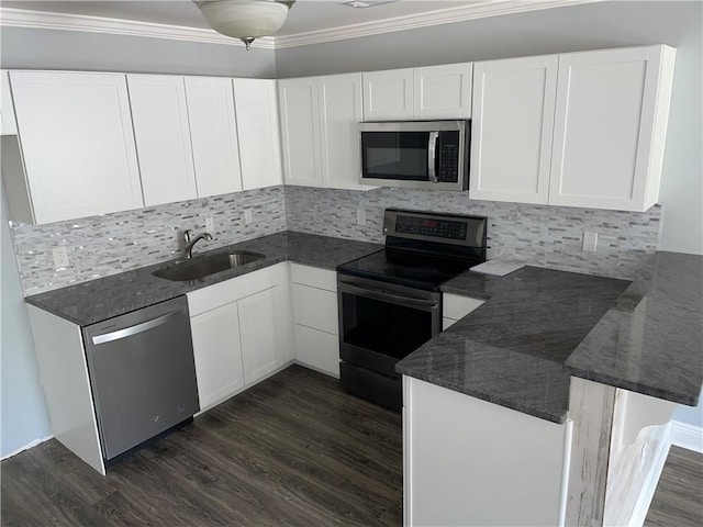 176 Meadowmoss Dr, Slidell, LA 70458 - kitchen featuring appliances with stainless steel finishes, a peninsula, dark wood-type flooring, white cabinetry, and ornamental molding