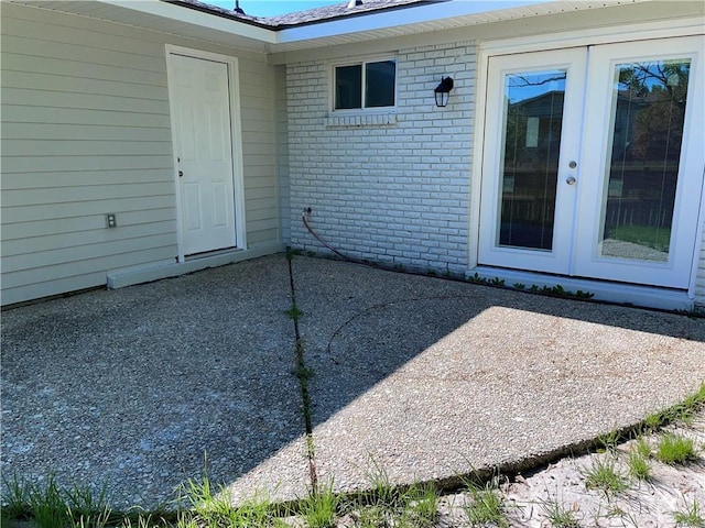 176 Meadowmoss Dr, Slidell, LA 70458 - property entrance with french doors, a patio area, and brick siding