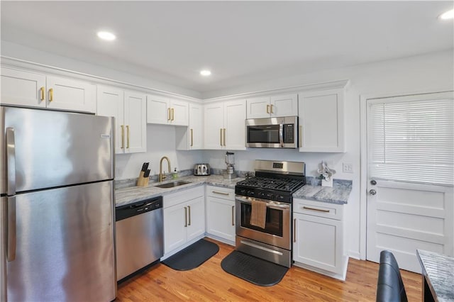3815 William Pl, Jefferson, LA 70121 - kitchen with stainless steel appliances, white cabinetry, light wood-style flooring, light stone counters, and recessed lighting
