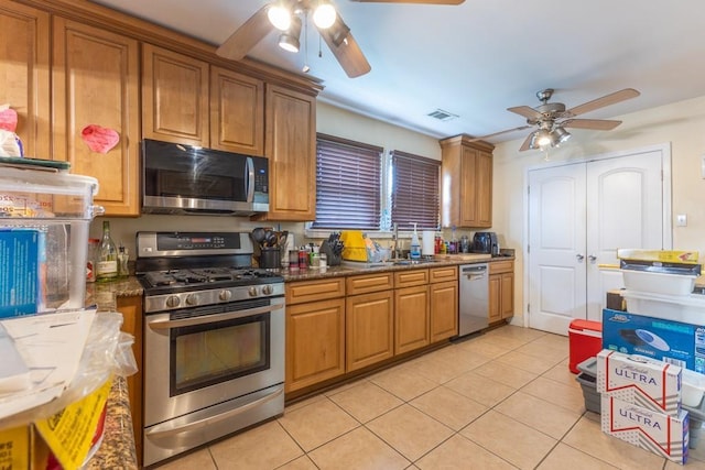 9112-14 Nelson St, New Orleans, LA 70118 - kitchen with appliances with stainless steel finishes, a ceiling fan, and brown cabinetry