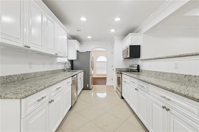 9962 E Wheaton Cir, New Orleans, LA 70127 - kitchen with stainless steel appliances, ornamental molding, white cabinetry, arched walkways, and recessed lighting