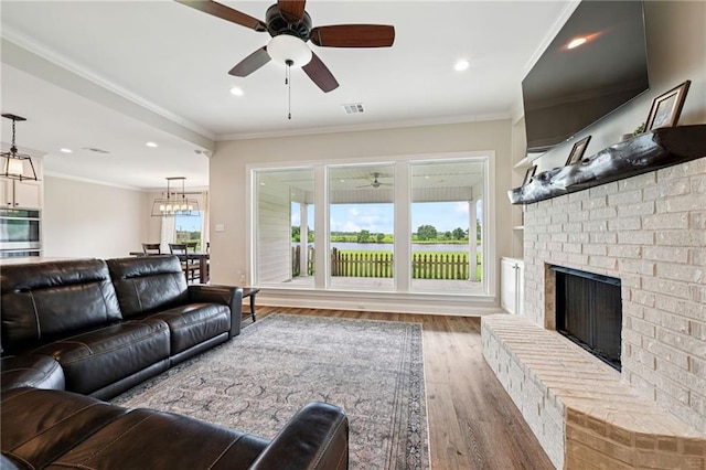 122 Highland Crest Dr, Covington, LA 70435 - living area featuring ceiling fan, wood finished floors, a fireplace, crown molding, and recessed lighting