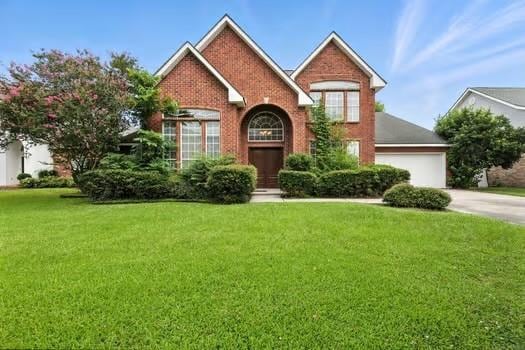 110 Woodchase Dr, Belle Chasse, LA 70037 - traditional-style house featuring driveway, a front lawn, brick siding, and an attached garage