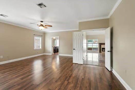 110 Woodchase Dr, Belle Chasse, LA 70037 - spare room featuring ornamental molding, plenty of natural light, a ceiling fan, and dark wood-style floors