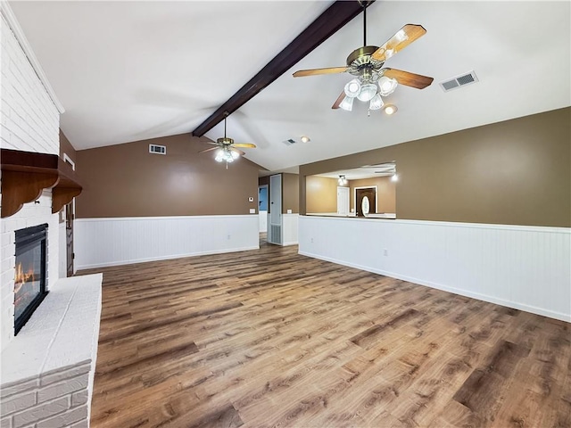 41449 N Charbonnet Rd, Ponchatoula, LA 70454 - unfurnished living room featuring a ceiling fan, wainscoting, wood finished floors, and a brick fireplace
