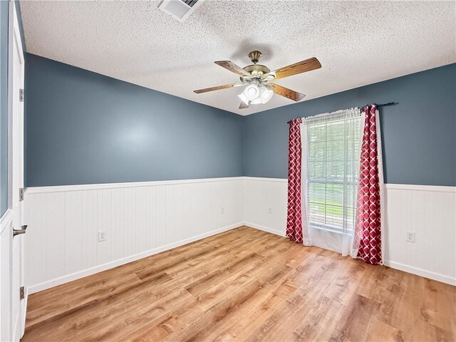 41449 N Charbonnet Rd, Ponchatoula, LA 70454 - unfurnished room featuring wood finished floors, wainscoting, a textured ceiling, and ceiling fan