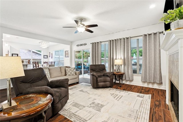 542 Huseman Ln, Covington, LA 70435 - living room featuring dark wood-style floors, ceiling fan, a chandelier, and a tile fireplace