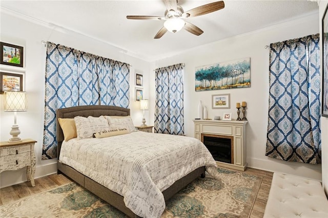 542 Huseman Ln, Covington, LA 70435 - bedroom with wood finished floors, ornamental molding, a ceiling fan, and a fireplace