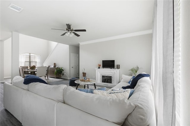 5681 Oakworth St, Slidell, LA 70461 - living area featuring a ceiling fan, crown molding, a fireplace with raised hearth, and wood finished floors
